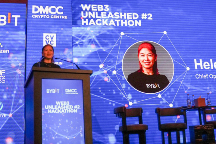 A panoramic view of the Web3 Unleashed hackathon stage in Dubai, featuring contestants presenting their blockchain innovations to an expert panel.