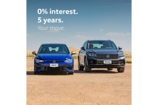 Showroom display of Volkswagen 2024 models with promotional banners.