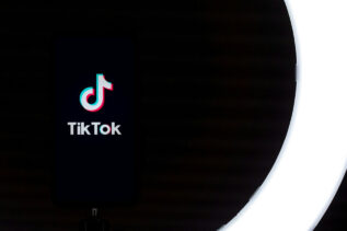 TikTok app logo displayed on a smartphone screen against a black background